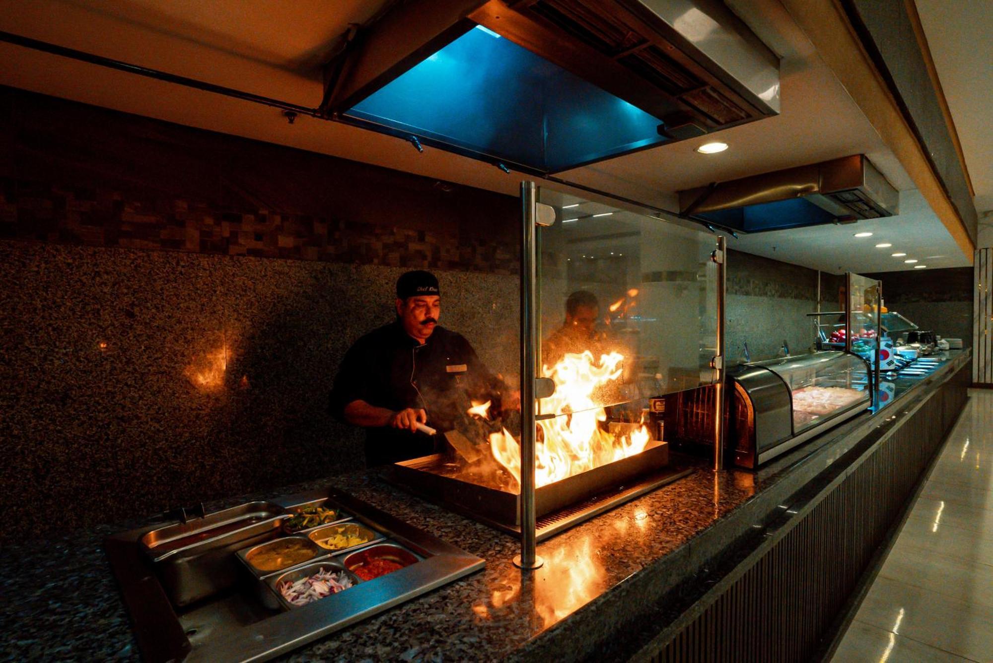 The V Luxury Resort Sahl Hasheesh Χουργκάντα Εξωτερικό φωτογραφία A chef cooking with a flaming torch